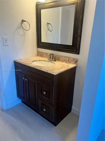 a bathroom with a granite countertop sink and a mirror
