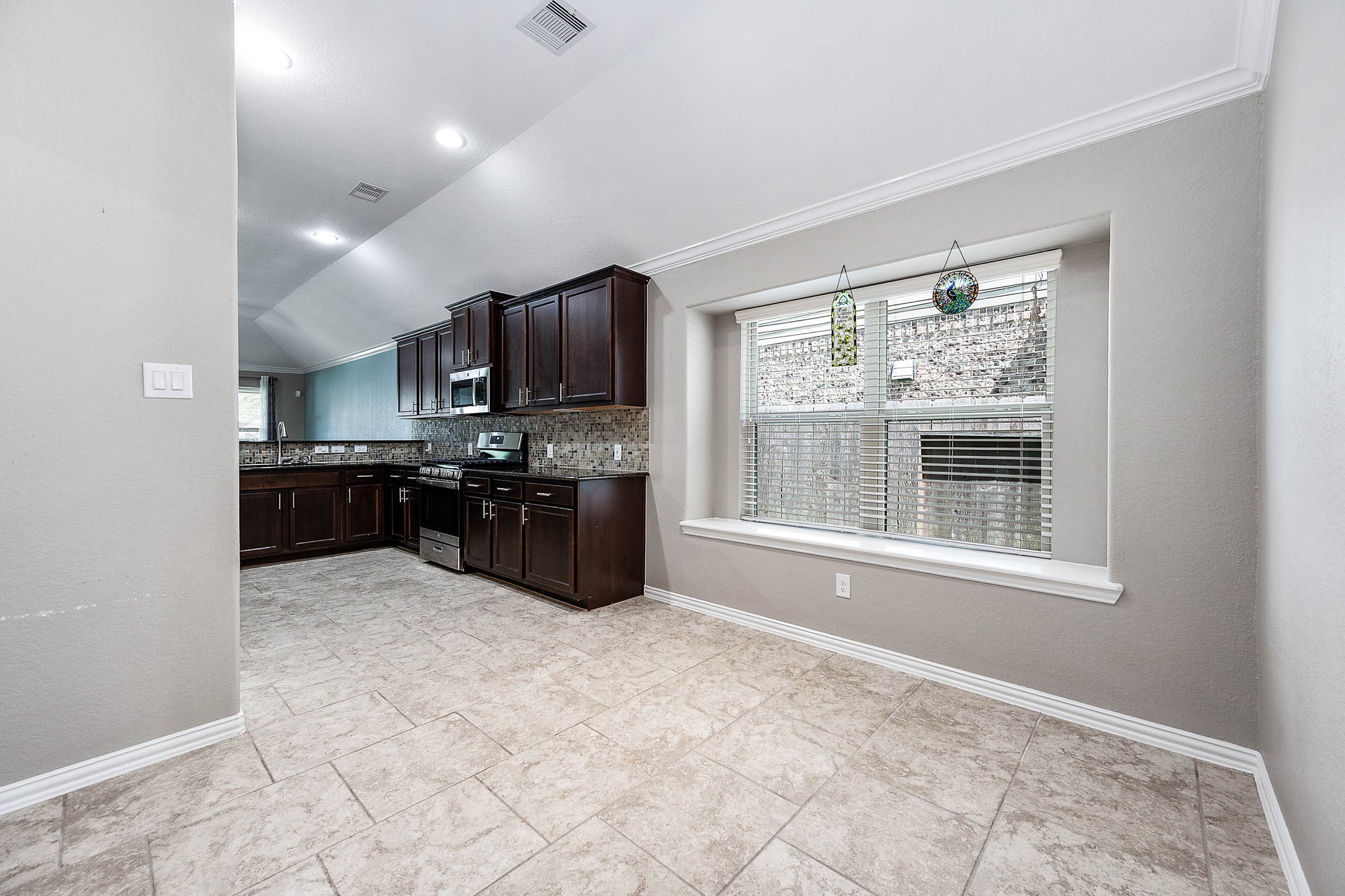 3050 Coreopsis Court Dickinson, TX 77539 - Photo 18 of 31 a large kitchen with kitchen island granite countertop a stove top oven a sink a counter space and cabinets