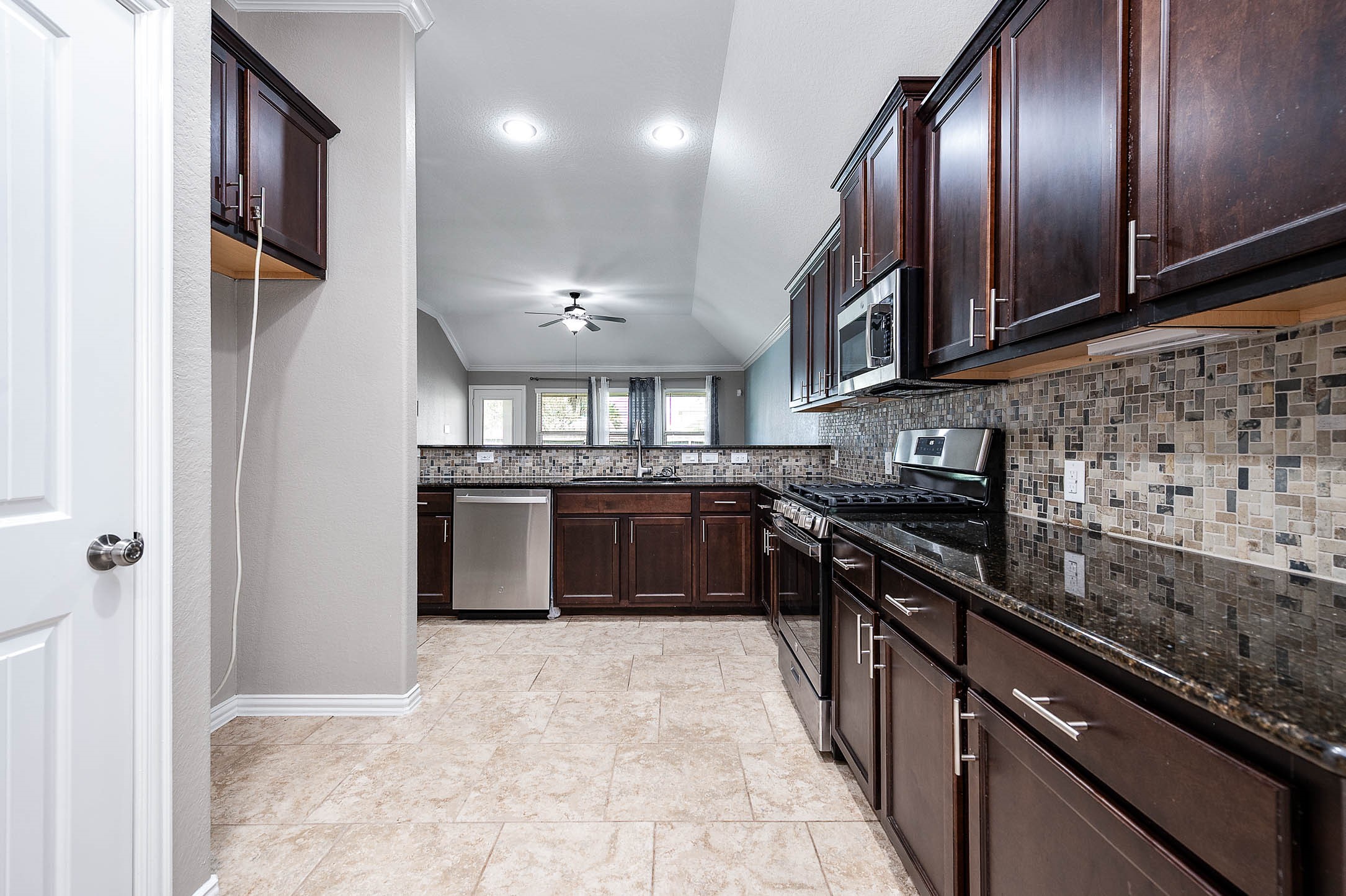 3050 Coreopsis Court Dickinson, TX 77539 - Photo 19 of 31 a kitchen with stainless steel appliances granite countertop a stove a sink and a refrigerator