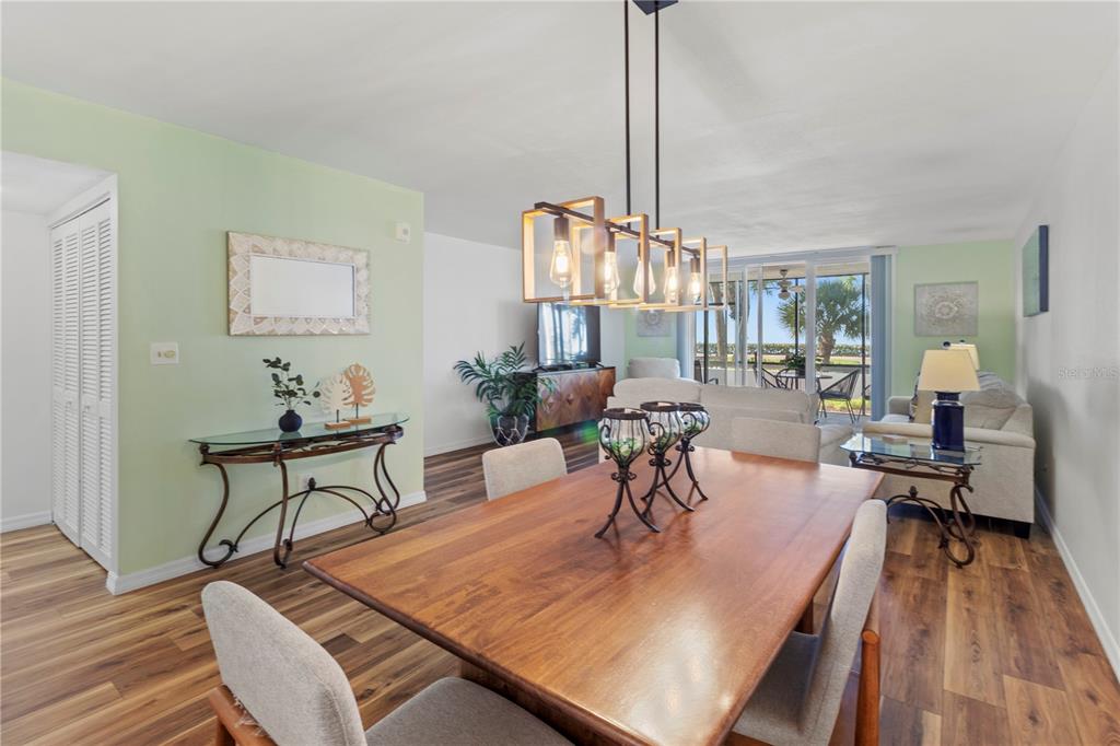 723 Bayport Way, Unit 723 Longboat Key, FL 34228 - Photo 13 of 67 a view of a dining room with furniture a chandelier and wooden floor