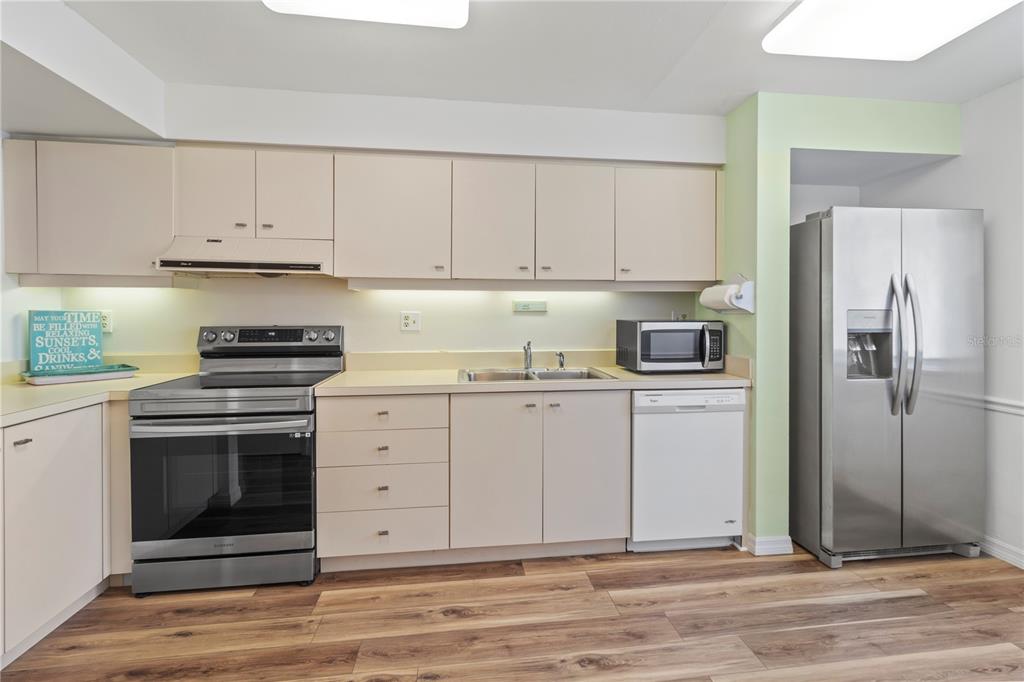 723 Bayport Way, Unit 723 Longboat Key, FL 34228 - Photo 7 of 67 a kitchen with white cabinets and stainless steel appliances