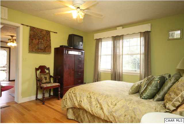 8607 3 Notch Road Louisa, VA 23093 - Photo 17 of 26 a bedroom with a bed and a chandelier
