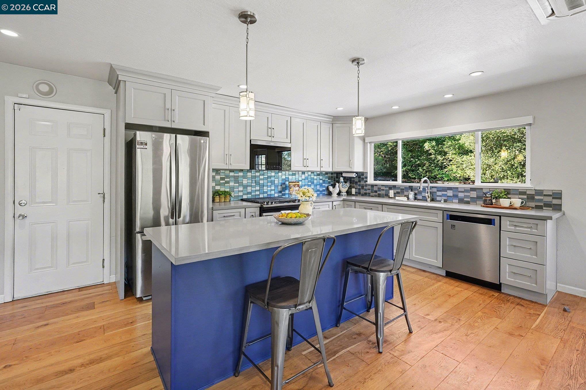 5745 Alhambra Valley Road Martinez, CA 94553 - Photo 15 of 47 a kitchen with stainless steel appliances a dining table chairs refrigerator and cabinets
