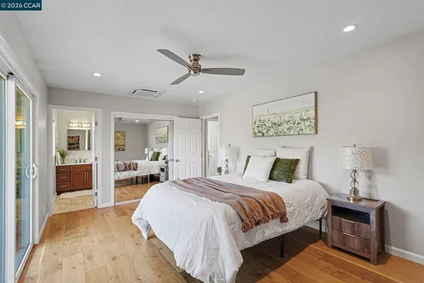 a spacious bedroom with a bed and wooden floor