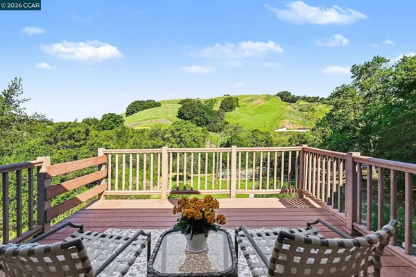 a view of balcony with wooden floor and fence
