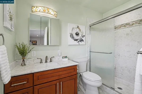 a bathroom with a sink a toilet and shower
