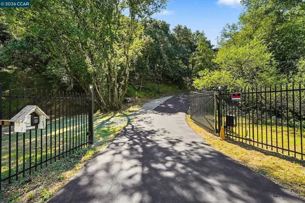 a view of a pathway with a wrought fence
