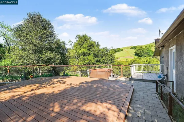 a view of a patio with table and chairs with wooden floor and fence