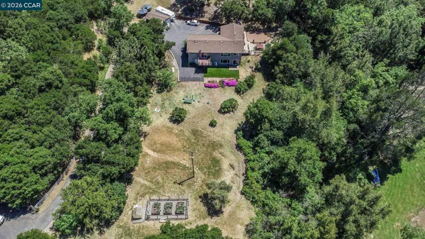 an aerial view of house with yard and parking space