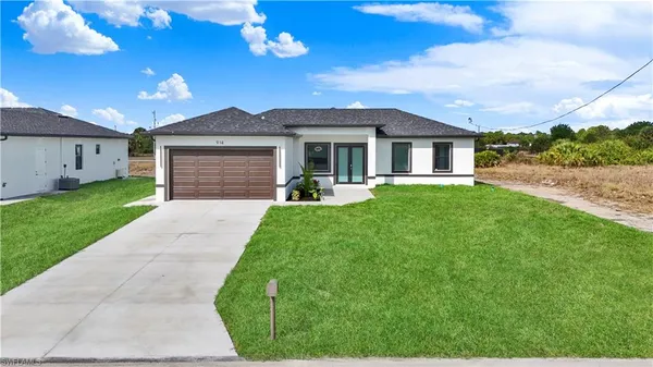 a front view of a house with a yard and garage