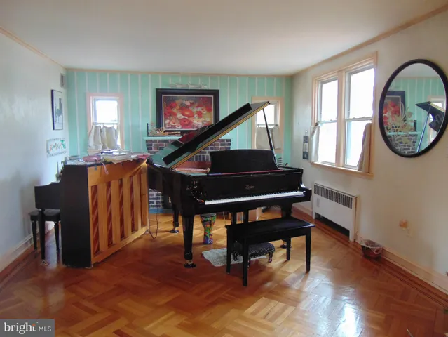 a living room with furniture a piano and a window