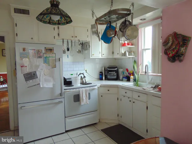 a kitchen with stainless steel appliances white cabinets and white appliances