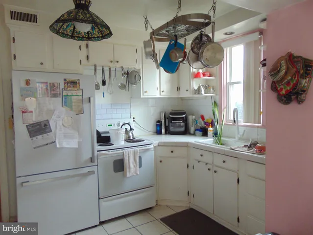 a kitchen with stainless steel appliances white cabinets and white appliances