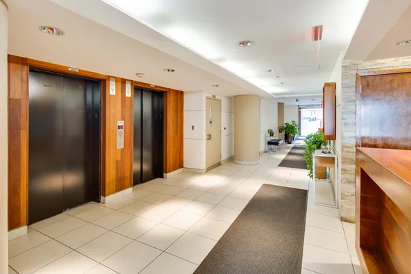a large white room with kitchen view and a refrigerator
