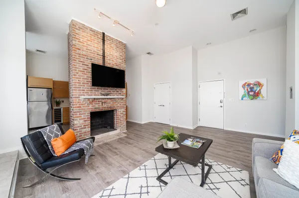 a living room with furniture a flat screen tv and a fireplace