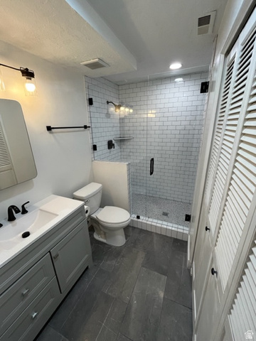 6884 670 East Midvale, UT 84047 - Photo 11 of 28 Bathroom featuring a closet, vanity, and a stall shower
