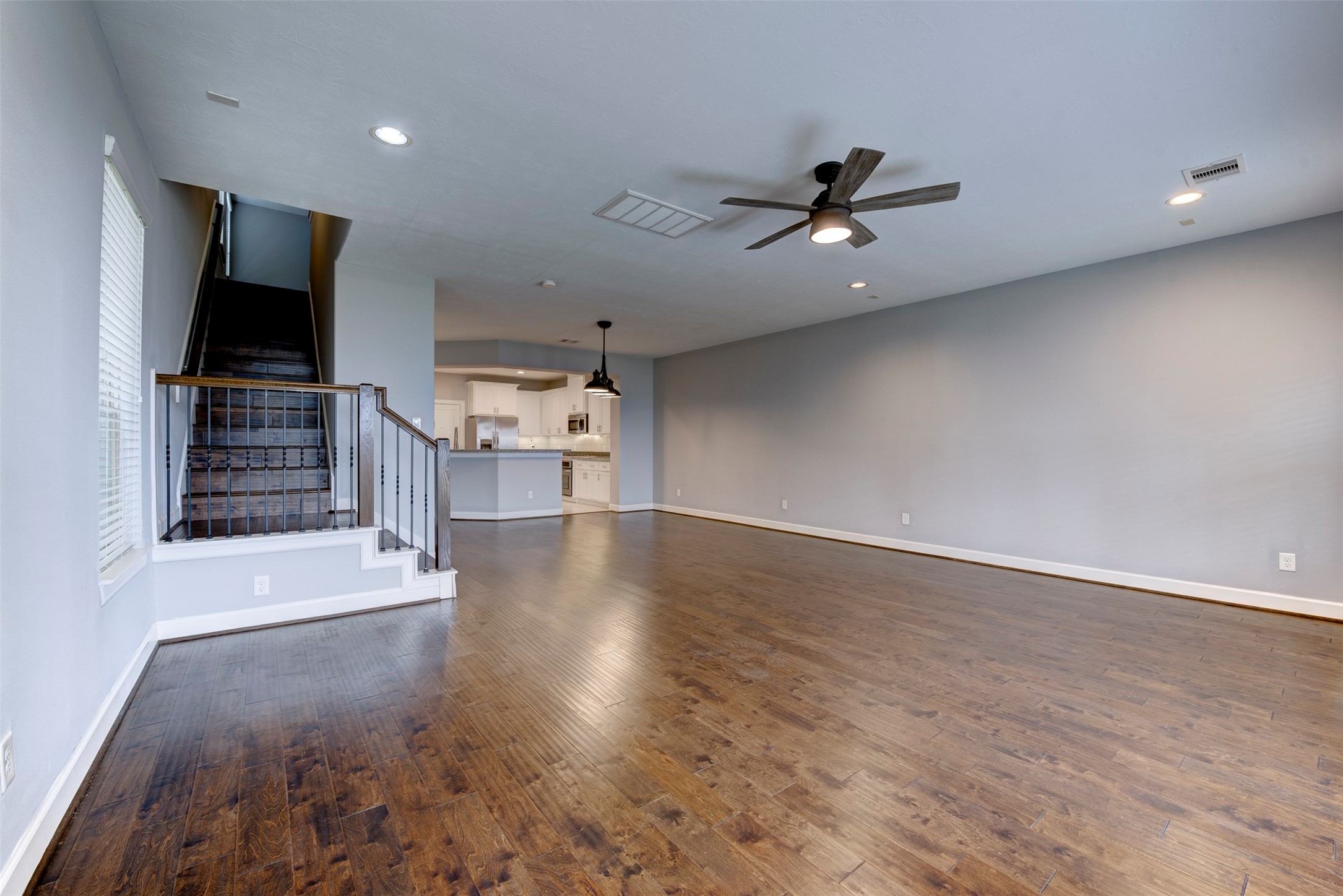 1811 Wichita Street, Unit A Houston, TX 77004 - Photo 11 of 36 an empty room with wooden floor ceiling fan and windows