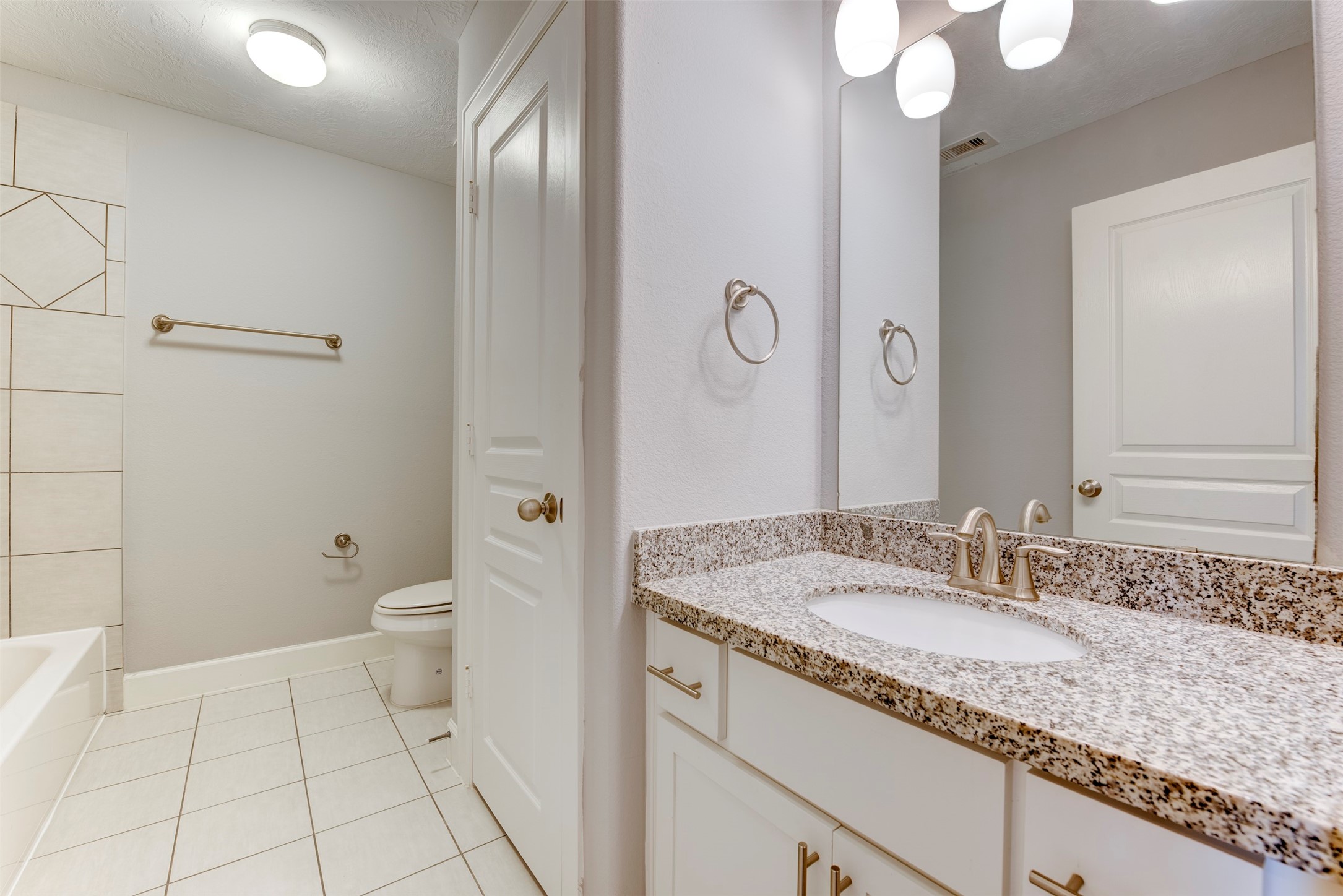 1811 Wichita Street, Unit A Houston, TX 77004 - Photo 25 of 36 a bathroom with a granite countertop sink a toilet and a mirror