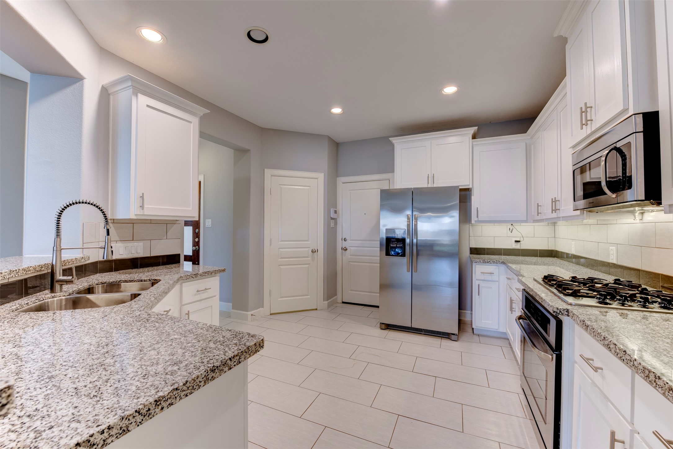 1811 Wichita Street, Unit A Houston, TX 77004 - Photo 6 of 36 a kitchen with stainless steel appliances granite countertop a stove a sink and a refrigerator