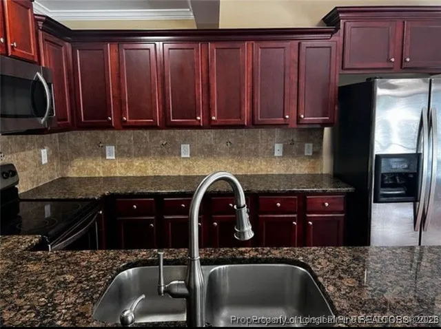 a kitchen with granite countertop a stove sink and cabinets