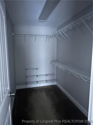 a view of walk in closet with empty racks