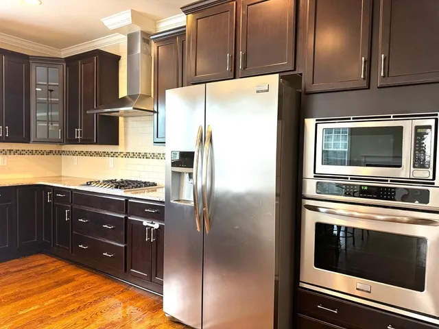 a kitchen with stainless steel appliances granite countertop a refrigerator stove and oven