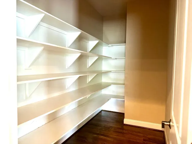 a view of walk in closet with wooden floor