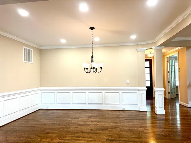 a view of an empty room with window wooden floor and front door