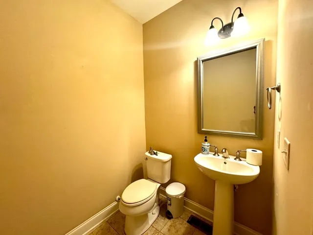 a bathroom with a sink mirror and a toilet