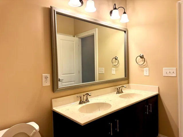 a bathroom with a granite countertop sink toilet tub and shower