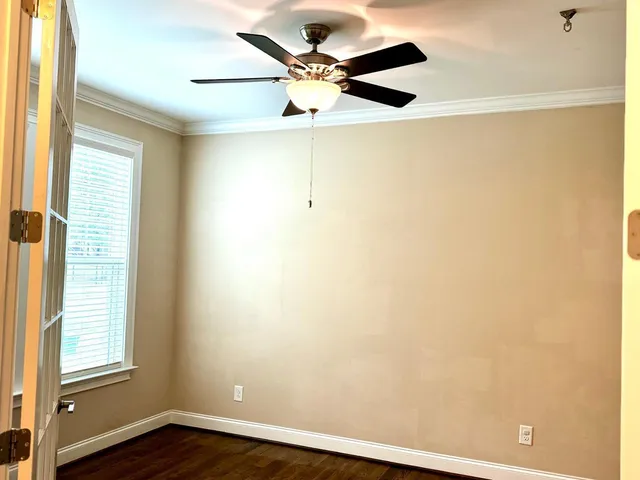 a view of an empty room with a window and a ceiling fan