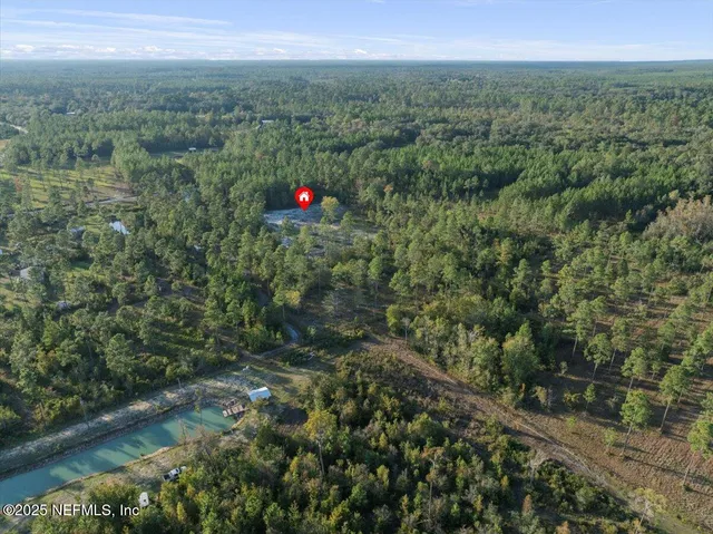 an aerial view of residential houses with outdoor space and trees