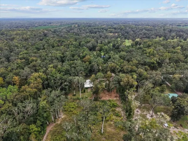 an aerial view of residential building with green space and fog