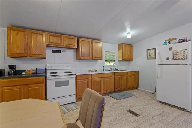 a kitchen with granite countertop a sink stove and refrigerator