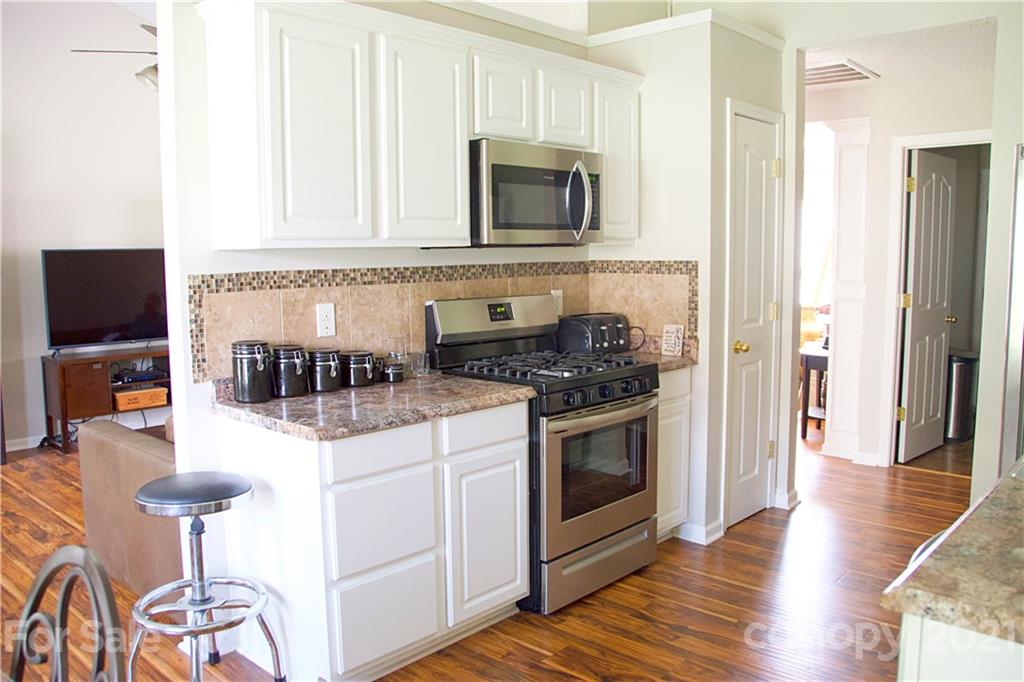 13415 Philip Michael Road Huntersville, NC 28078 - Photo 11 of 30 a kitchen with stainless steel appliances granite countertop a stove and a microwave