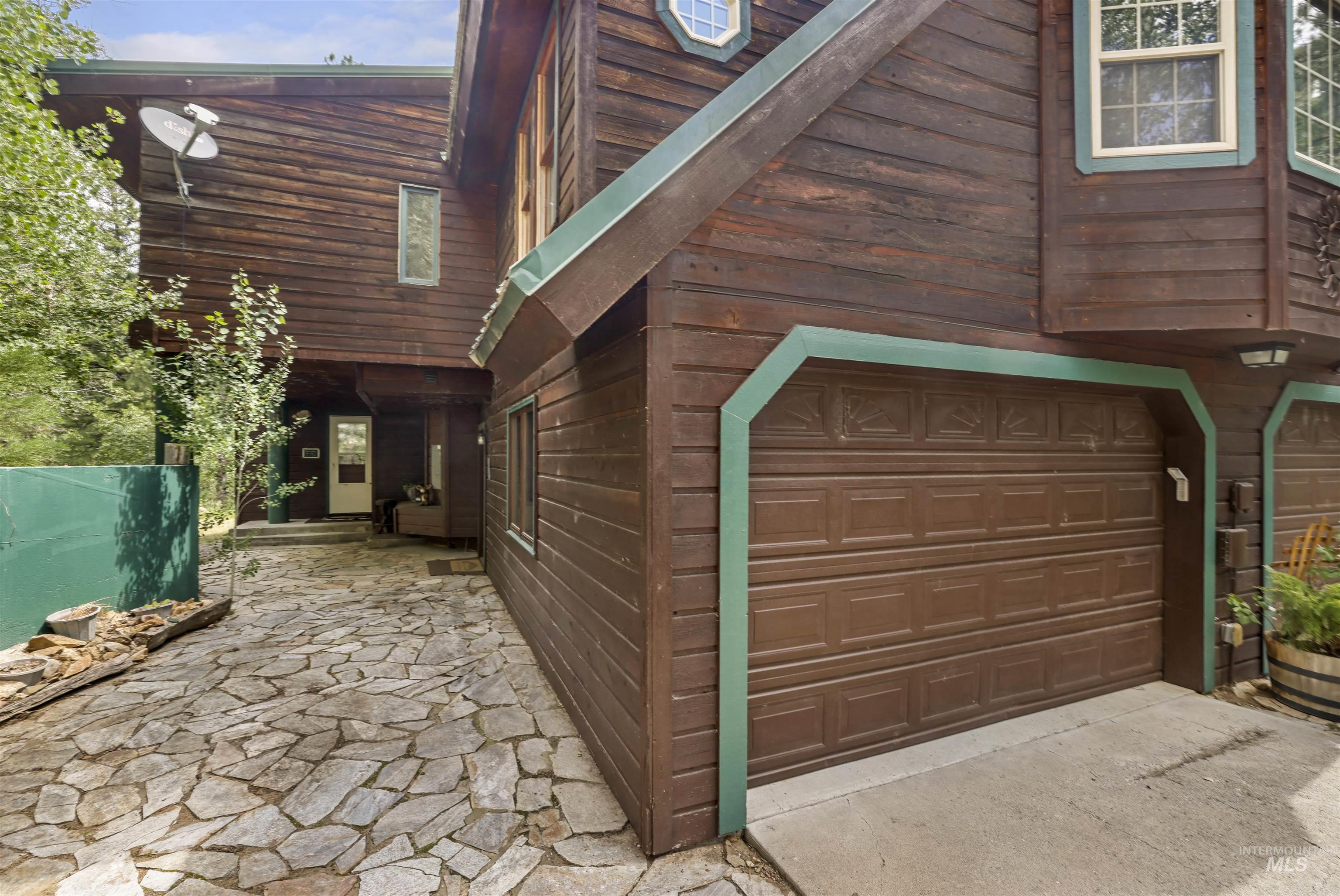 224 Dakota Road Mountain Home, ID 83647 - Photo 42 of 50 Wood-sided exterior featuring an attached garage with a brown panel door and green trim