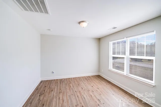 a view of hallway with a large window and wooden floor