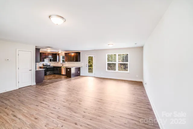 a view of a livingroom with wooden floor and a fireplace
