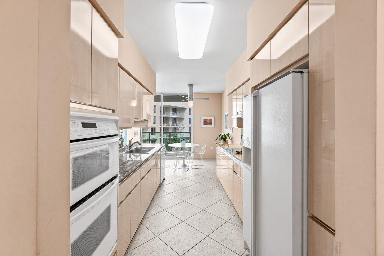 500 Southeast Mizner Boulevard, Unit A411 Boca Raton, FL 33432 - Photo 14 of 67 a kitchen with granite countertop a refrigerator and a stove top oven