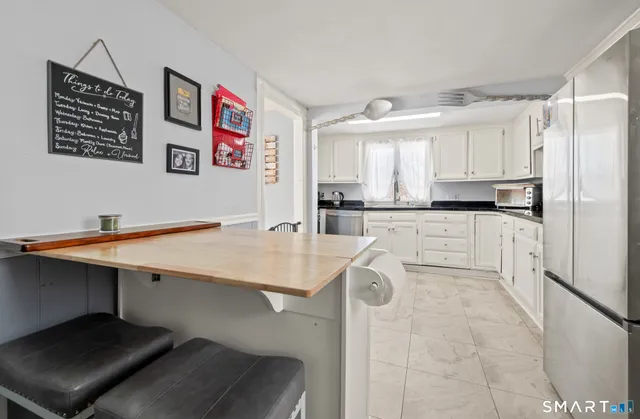 a kitchen with stainless steel appliances a sink a stove a refrigerator and cabinets