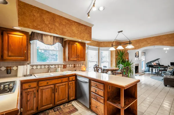 a kitchen with stainless steel appliances a sink a counter top space and living room view