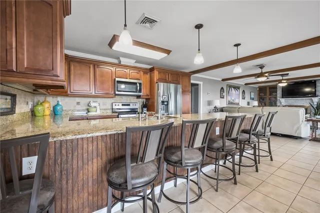 a kitchen with stainless steel appliances granite countertop a kitchen island hardwood floor and a sink