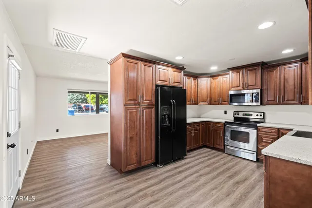a kitchen with stainless steel appliances granite countertop a refrigerator stove and sink
