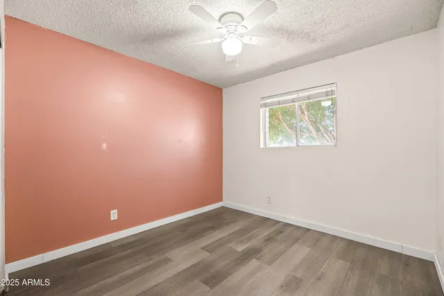 an empty room with a window and a fan