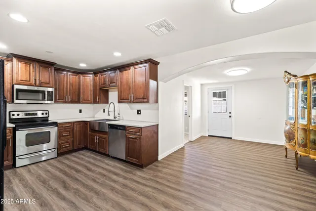 a kitchen with granite countertop a sink cabinets and stainless steel appliances