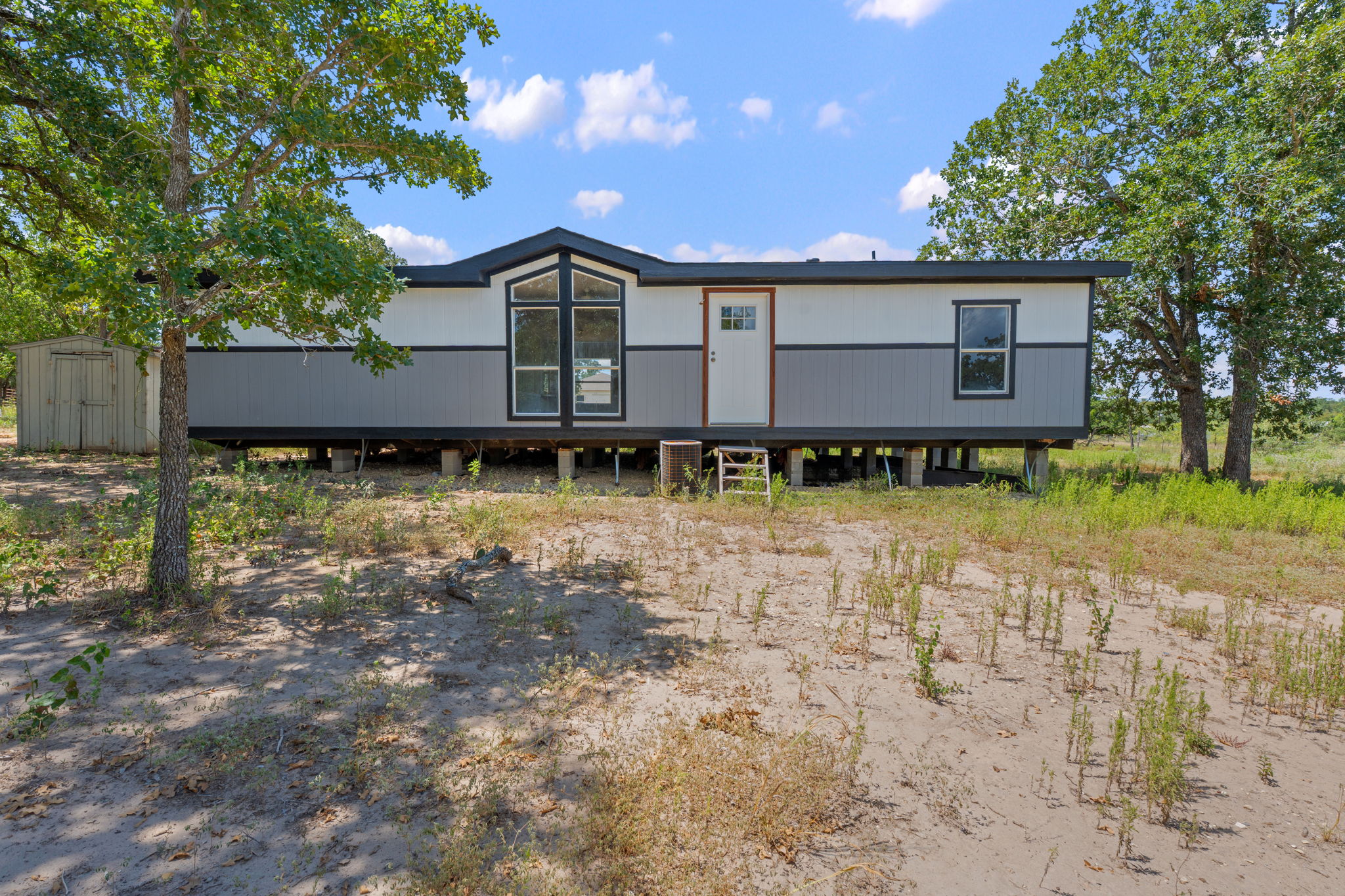 View of front of home featuring a storage shed