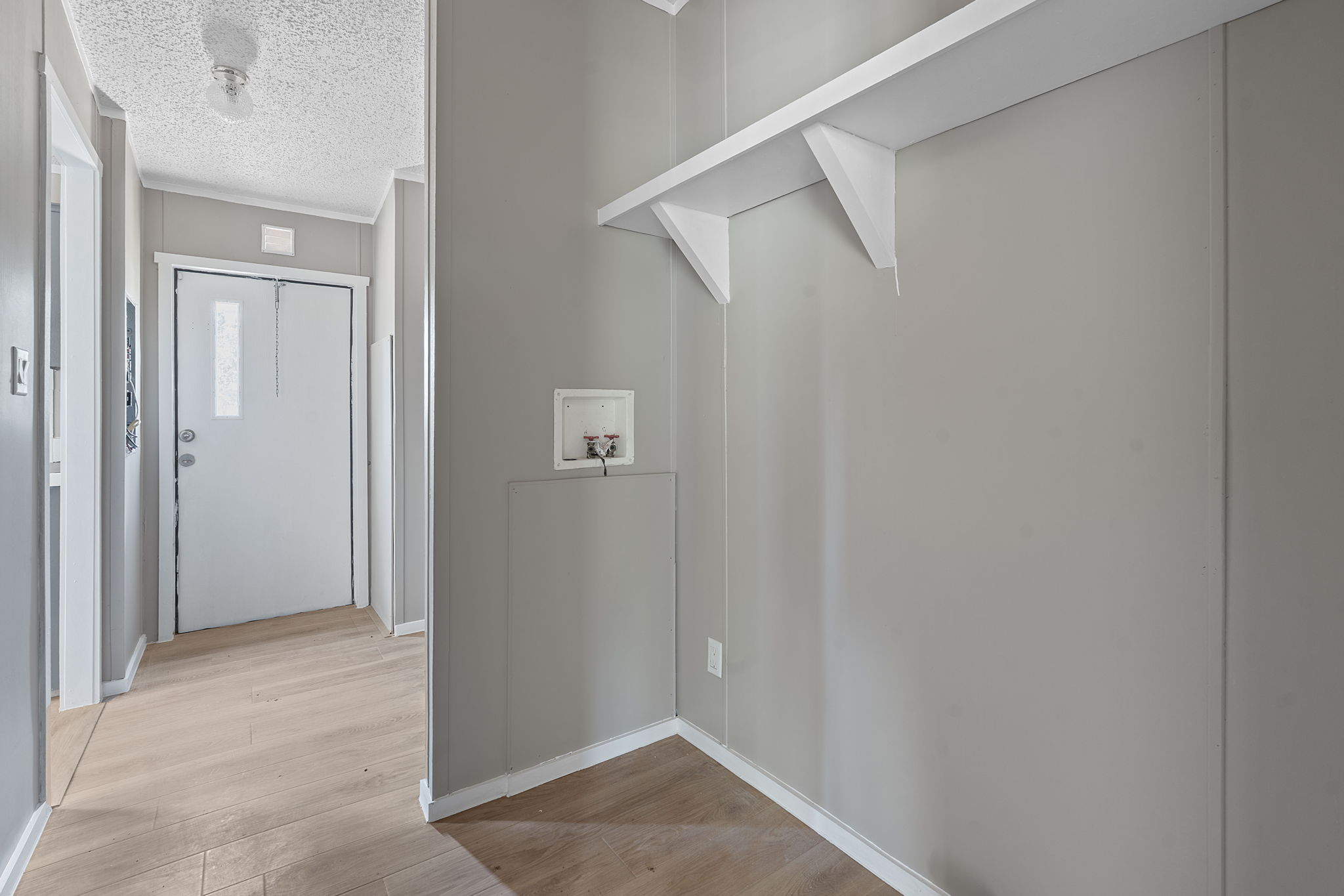 1385 Pettytown Road Dale, TX 78616 - Photo 5 of 17 Laundry room featuring light wood finished floors, washer hookup, and a textured ceiling