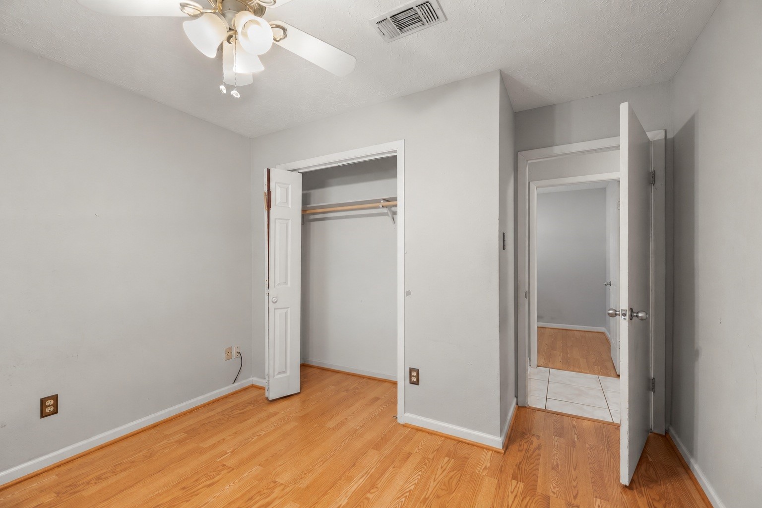 23826 Lestergate Drive Spring, TX 77373 - Photo 26 of 45 Turning back toward the hallway, this angle shows the bedroom’s closet along the left wall and the open doorway leading back into the hall. Laminate flooring continues underfoot—NO CARPET here—while the closet keeps storage close at hand before we continue to the final bedroom.