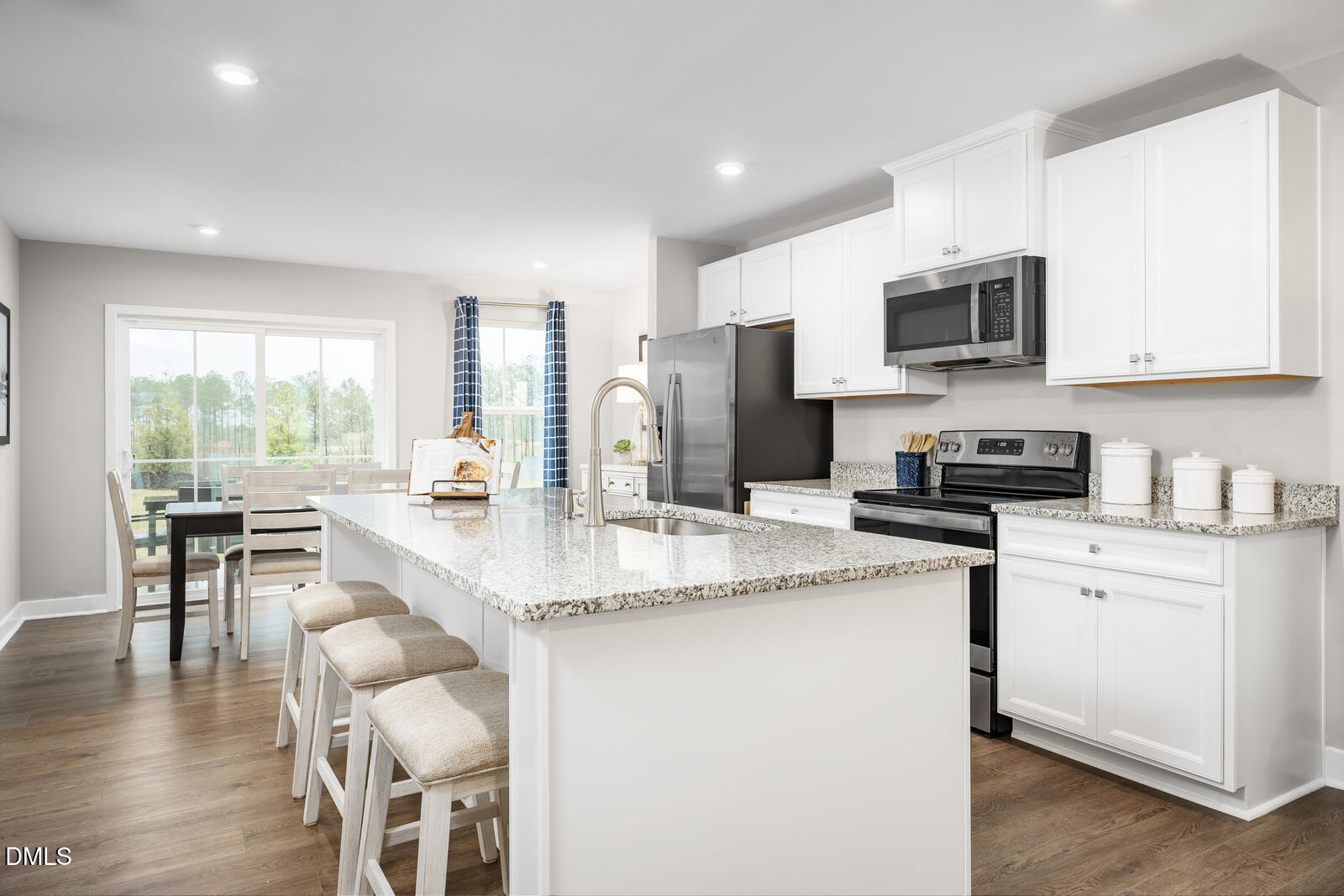 505 Nemesia Drive Wendell, NC 27591 - Photo 2 of 23 a kitchen with stainless steel appliances granite countertop a stove a sink a microwave a refrigerator and white cabinets with wooden floor