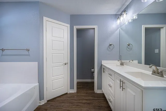 a bathroom with a double vanity sink and a mirror